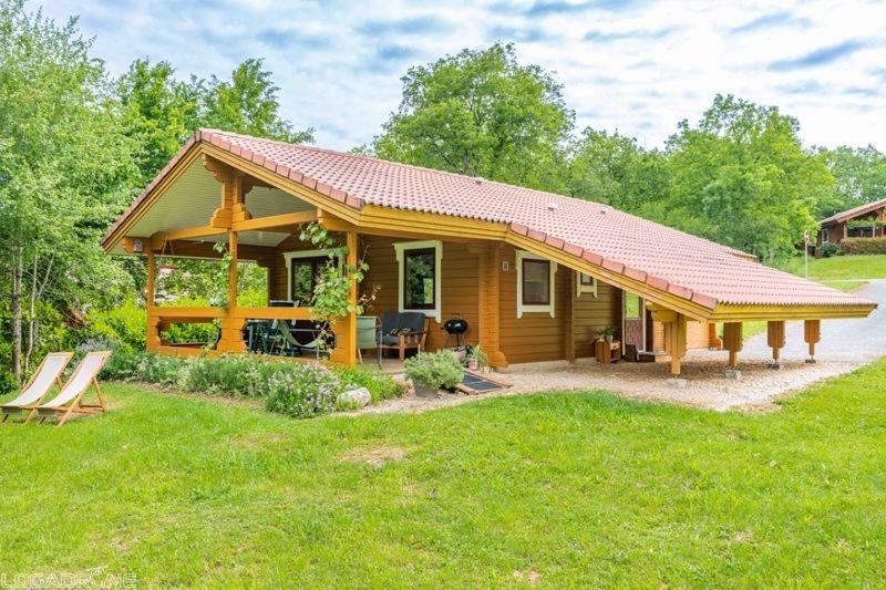 mały drewniany domek na podwórku z trawą w obiekcie Chalet 17 tournesol Mauroux w mieście Mauroux