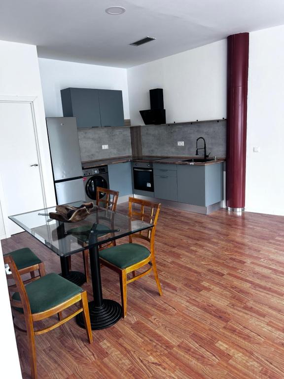 a kitchen with a glass table and chairs in a room at La estación in Villafranca del Bierzo