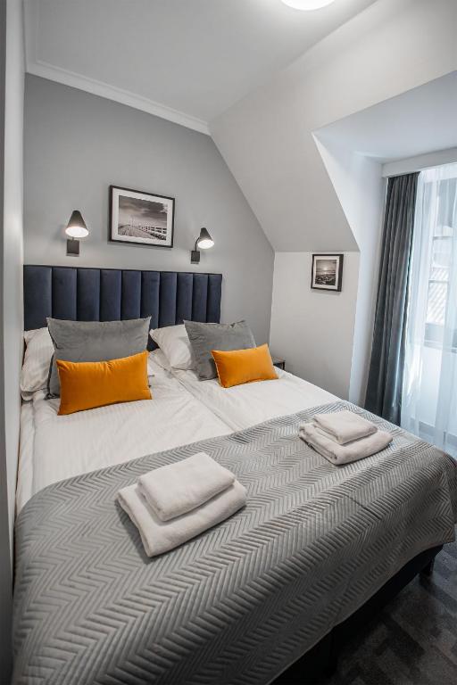 a bedroom with a large bed with two towels on it at Soul Rooms Old Town Gdansk in Gdańsk