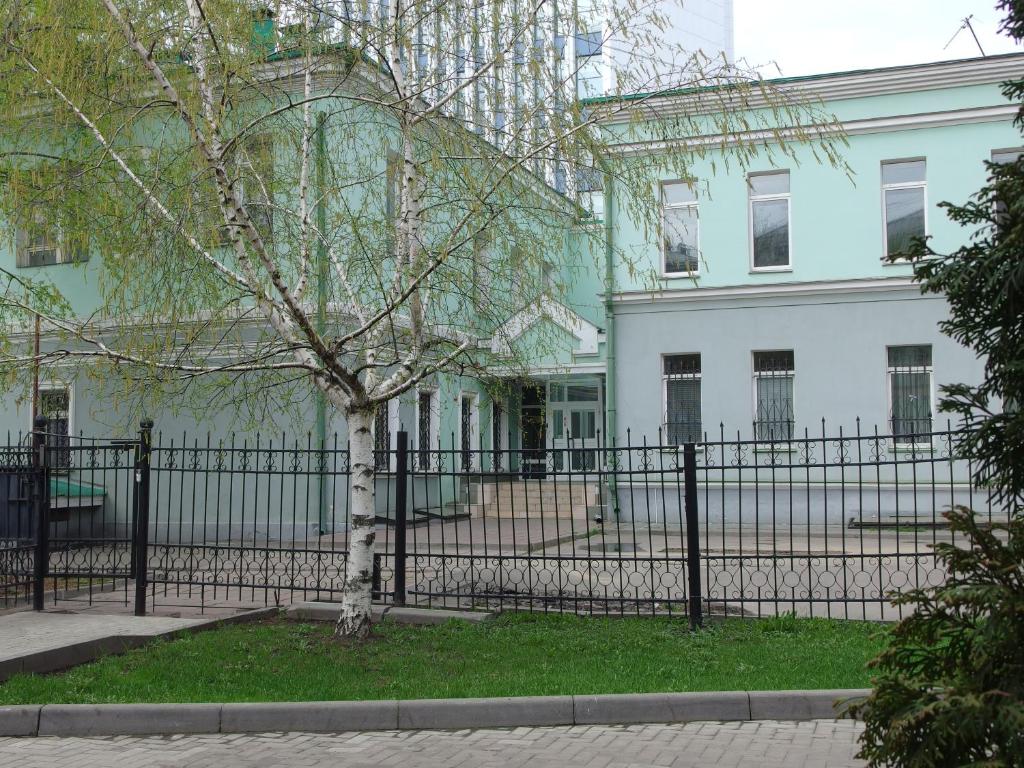 a fence with a tree in front of a building at Basmanka Convent Hotel in Moscow