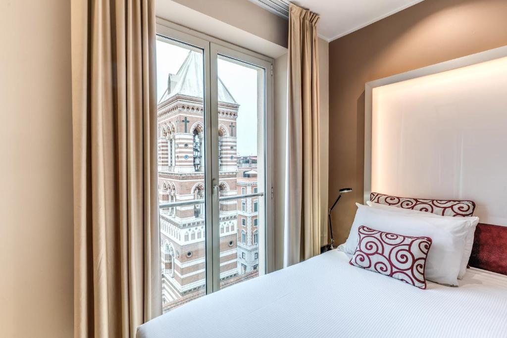 a bedroom with a bed and a large window at La Griffe Hotel Roma in Rome