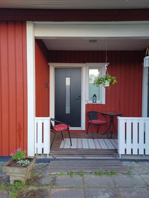 a front porch of a red house with a table and chairs at Mumrila in Pori