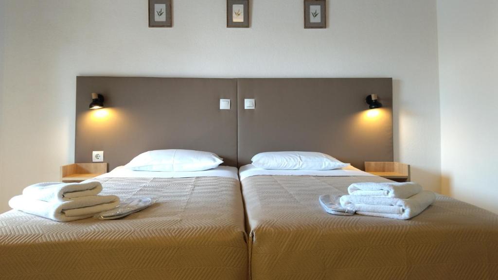 a bedroom with two beds with towels on them at Villa Anna Maria in Agia Paraskevi