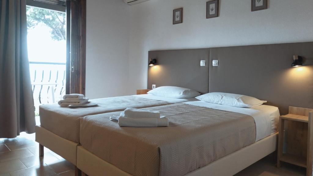 a bedroom with a large bed with towels on it at Villa Anna Maria in Agia Paraskevi