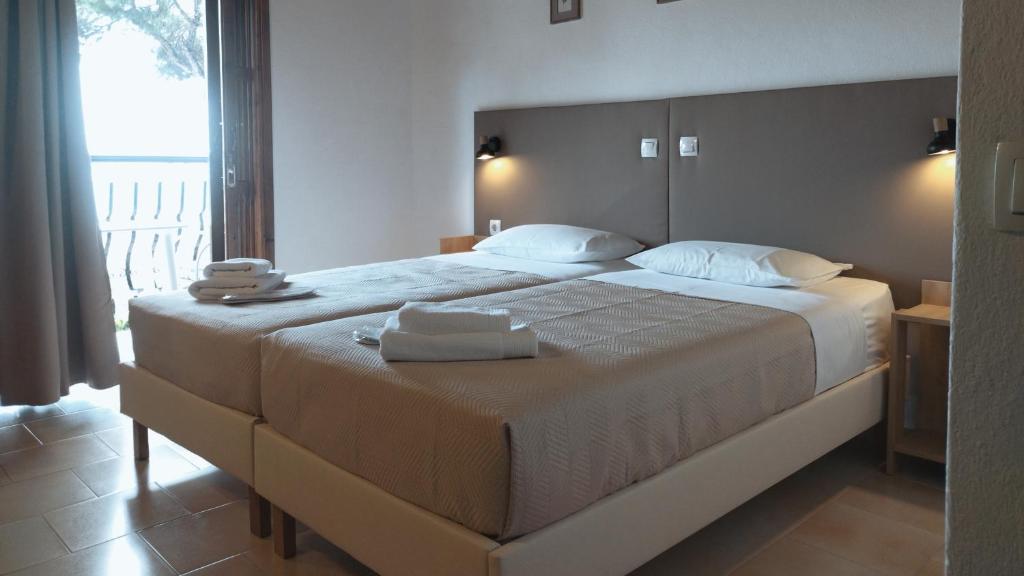 a bedroom with a large bed with towels on it at Villa Anna Maria in Agia Paraskevi