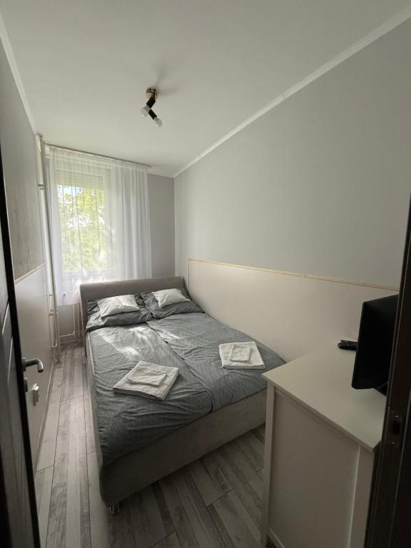 a small bedroom with a bed and a window at Boulevard Apartman in Nyíregyháza