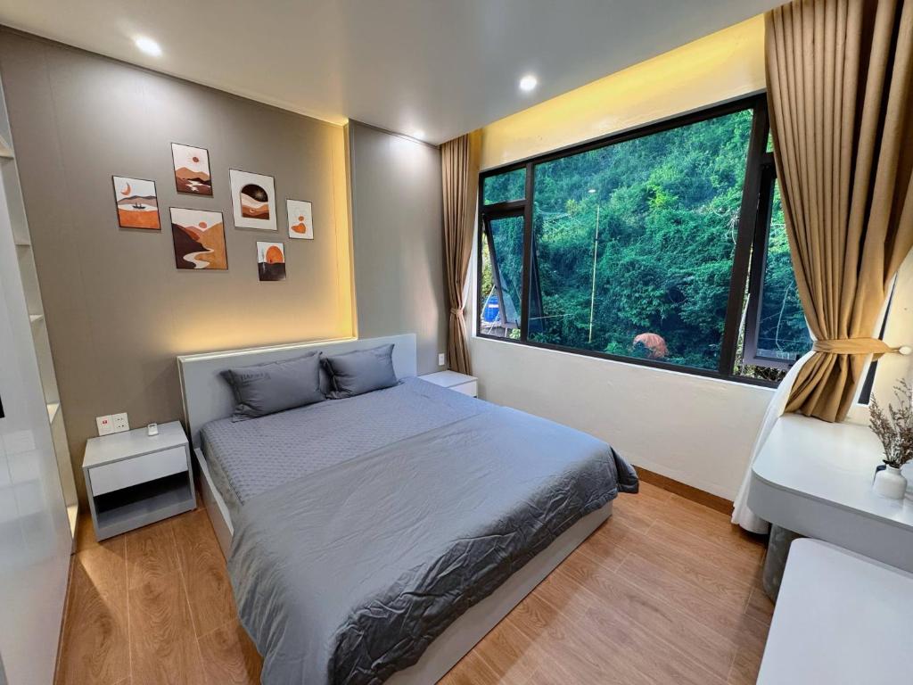 a bedroom with a bed and a large window at CAT BA Villas 5 Rooms in Cat Ba