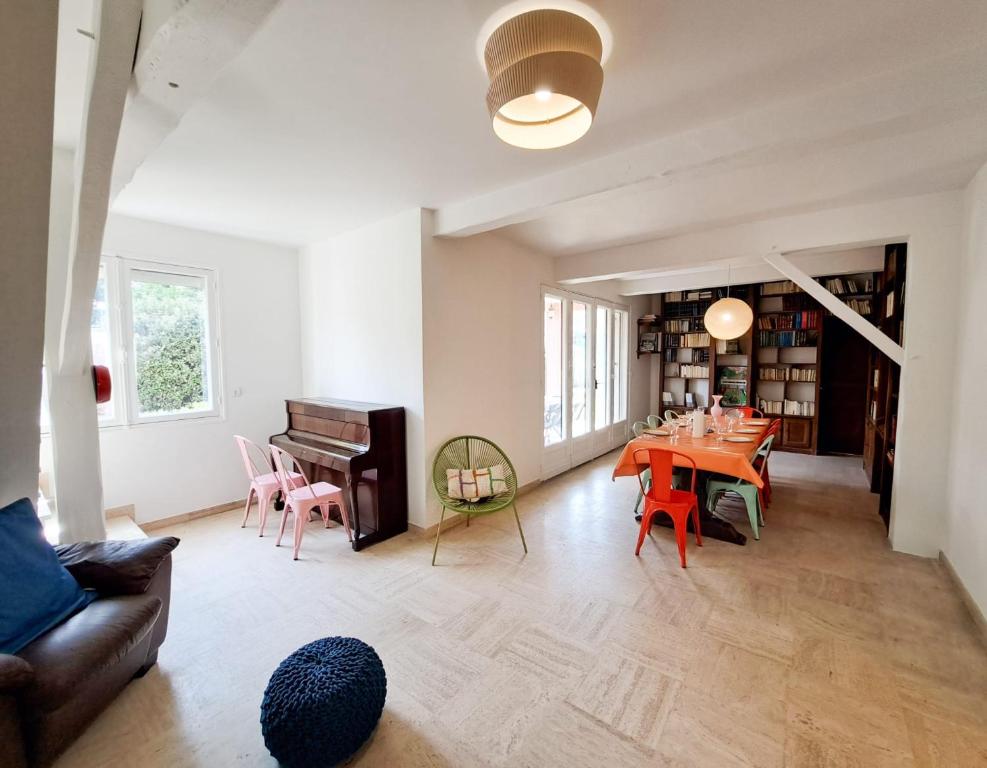 un salon avec une table et un piano dans l'établissement Nonni - MAISON FAMILIALE AVEC JARDIN, PROCHE DE LA GARE ET A 10MIN DE LA PLAGE, à Royan
