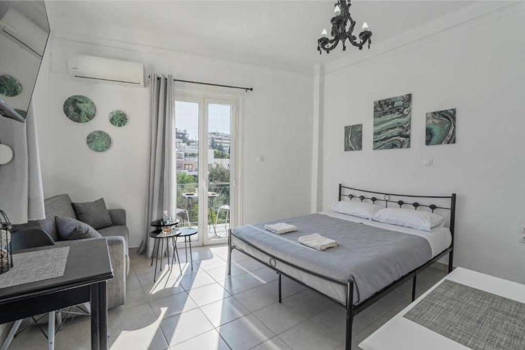 a white bedroom with a bed and a couch at Chrysi Guesthouse in Rethymno
