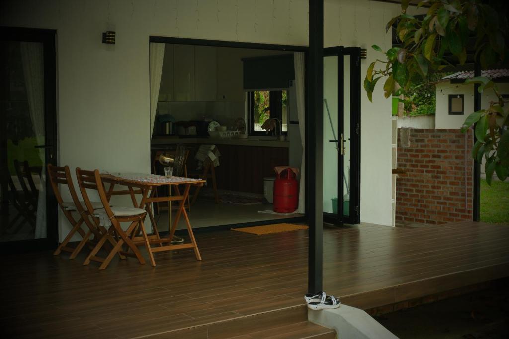 Un comedor y una cocina con mesa y sillas. en villa barakah, en Bentong