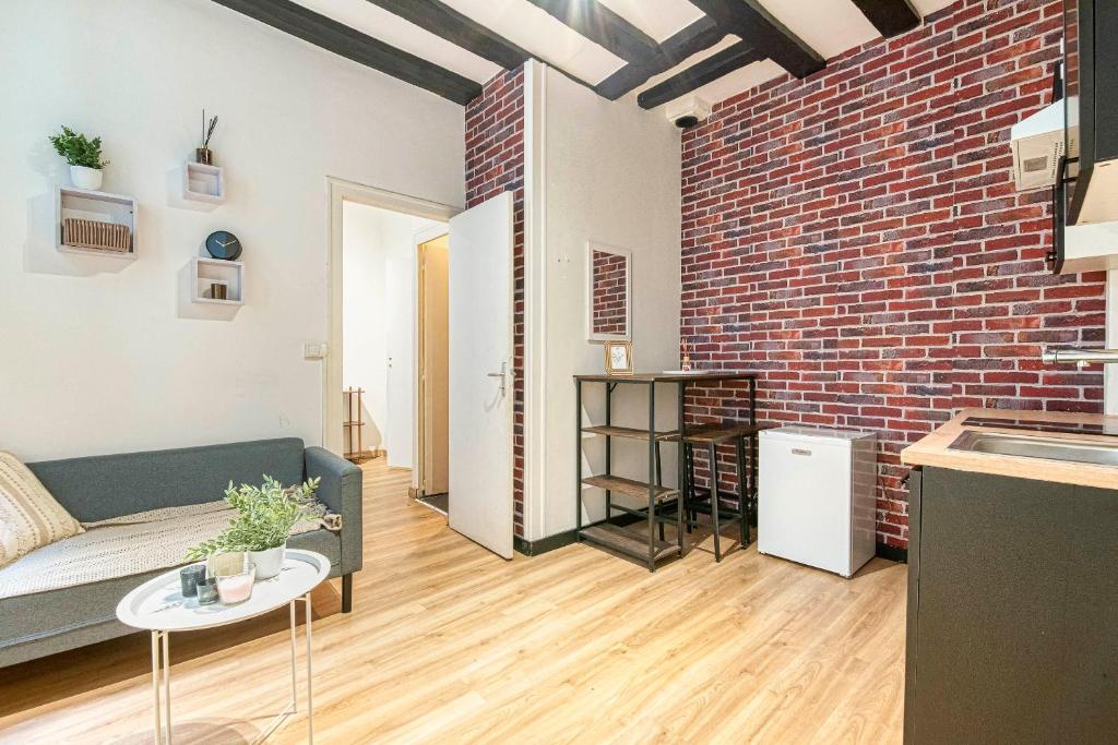 un salon avec un canapé et un mur de briques dans l'établissement L'Atelier d'Angers, à Angers