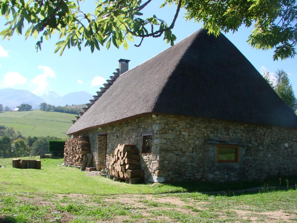 un ancien bâtiment en pierre avec un toit en gazon dans l'établissement La Chaumière aux Biches, à La Celle-sous-Gouzon
