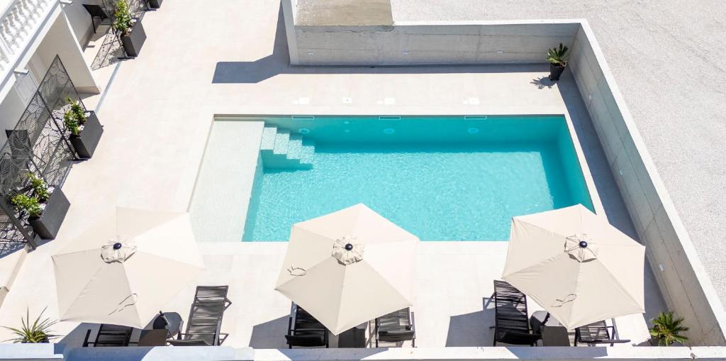 een uitzicht over een zwembad met parasols bij Villa Mia - Moderne Oase mit Meerblick und Pool in Vodice