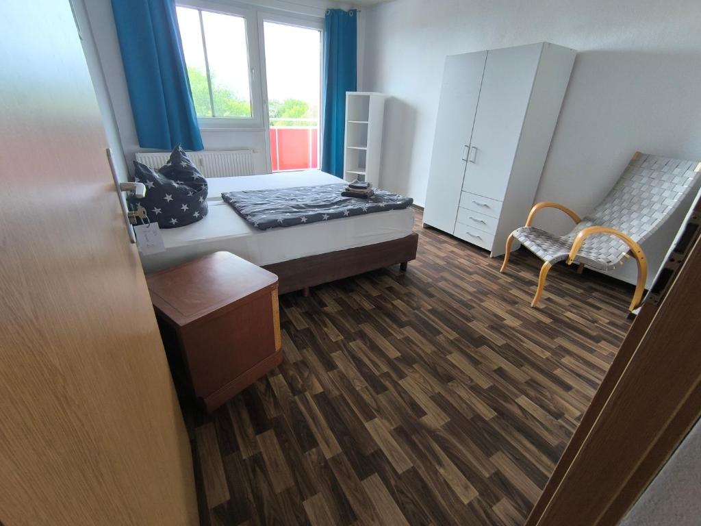 a room with a bed and a chair and a window at Möbliert Wohnen in Weickelsdorf in Bahnhof Weickelsdorf