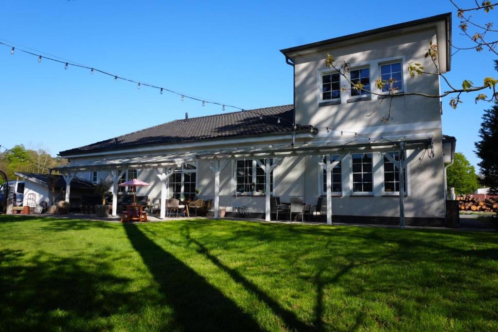 a white house with a lawn in front of it at Wohnen im Stielwerk in Munster im Heidekreis