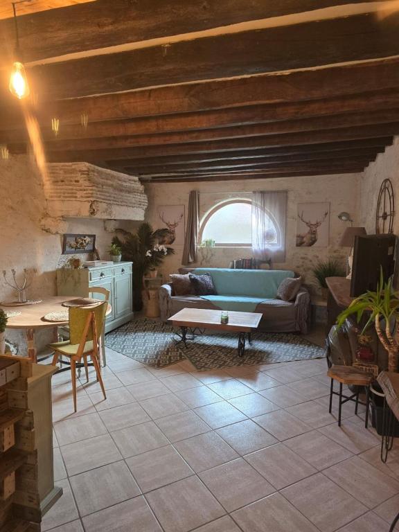un salon avec un canapé et une table dans l'établissement Une nuit au domaine, à Saint-Léonard-en-Beauce