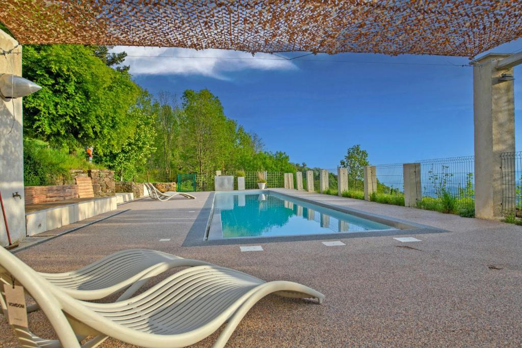 a swimming pool with a chaise lounge next to a pool at Peponi Classé 4 étoiles - Piscine - Parc des Monts d'Ardèche in Gourdon
