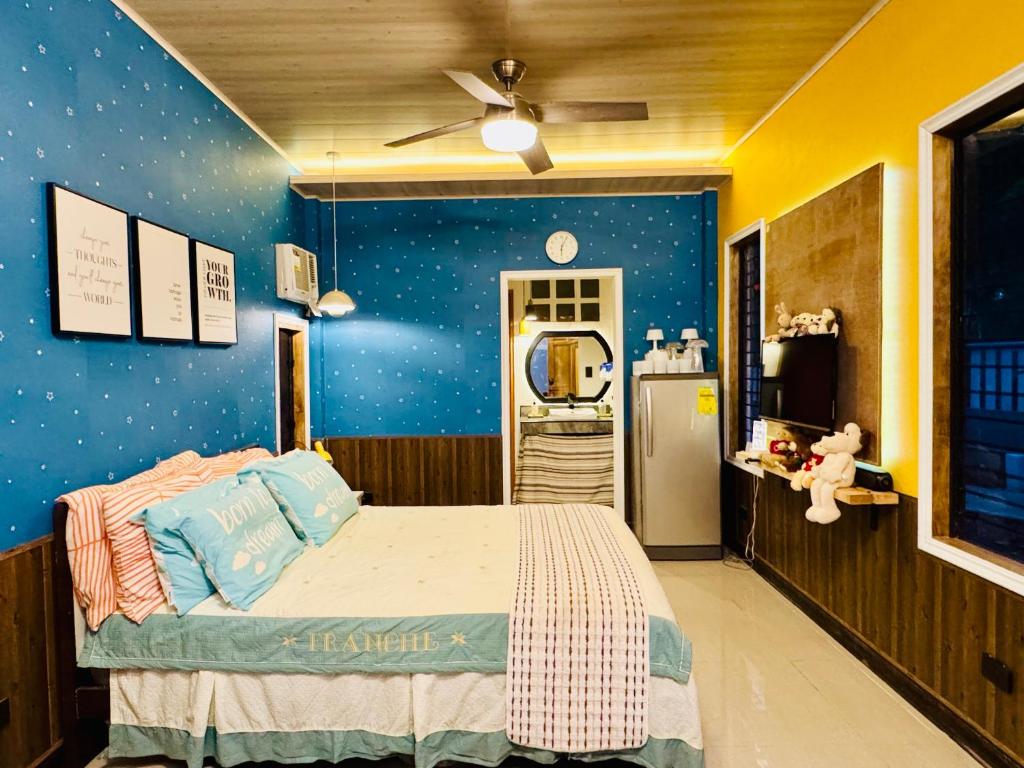 a bedroom with a bed with a blue wall with stars at Bohol Seafront Villa Pasan Cove a resort homestay in Guindulman