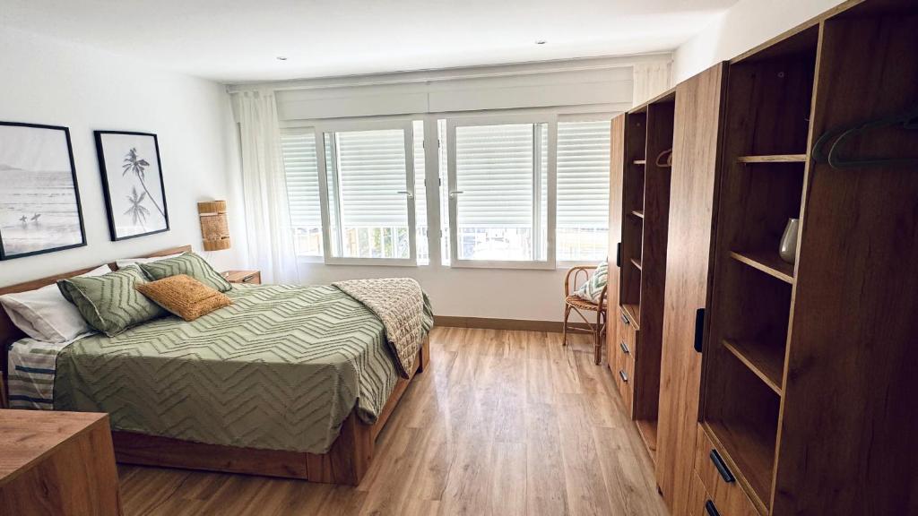 a bedroom with a bed and a large window at Casa en el centro , con amplia terraza in Vinarós