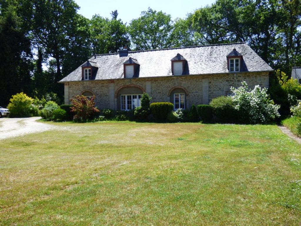 une maison en pierre avec une cour herbeuse dans l'établissement Château de BEL AIR, à Aucaleuc