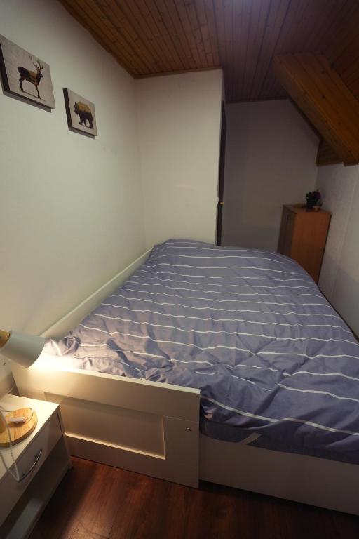 a bedroom with a bed with a blue comforter at Mladenović Kuća in Kopaonik