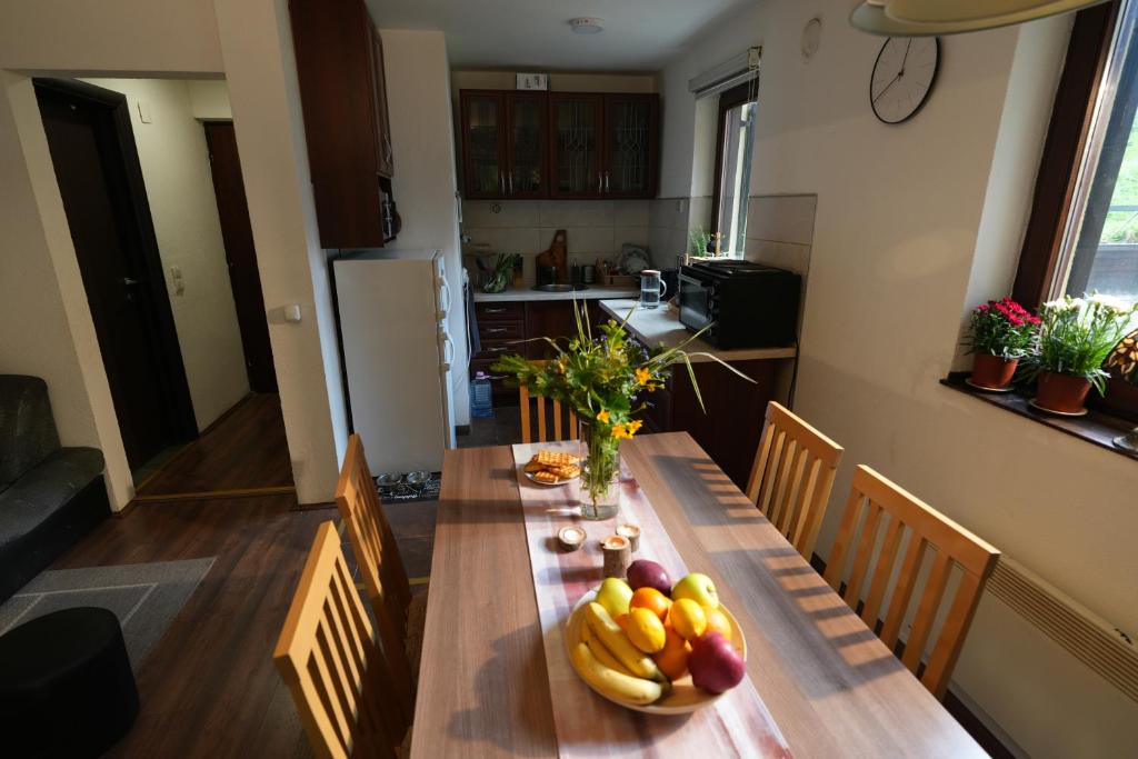a kitchen with a wooden table with fruit on it at Mladenović Kuća in Kopaonik