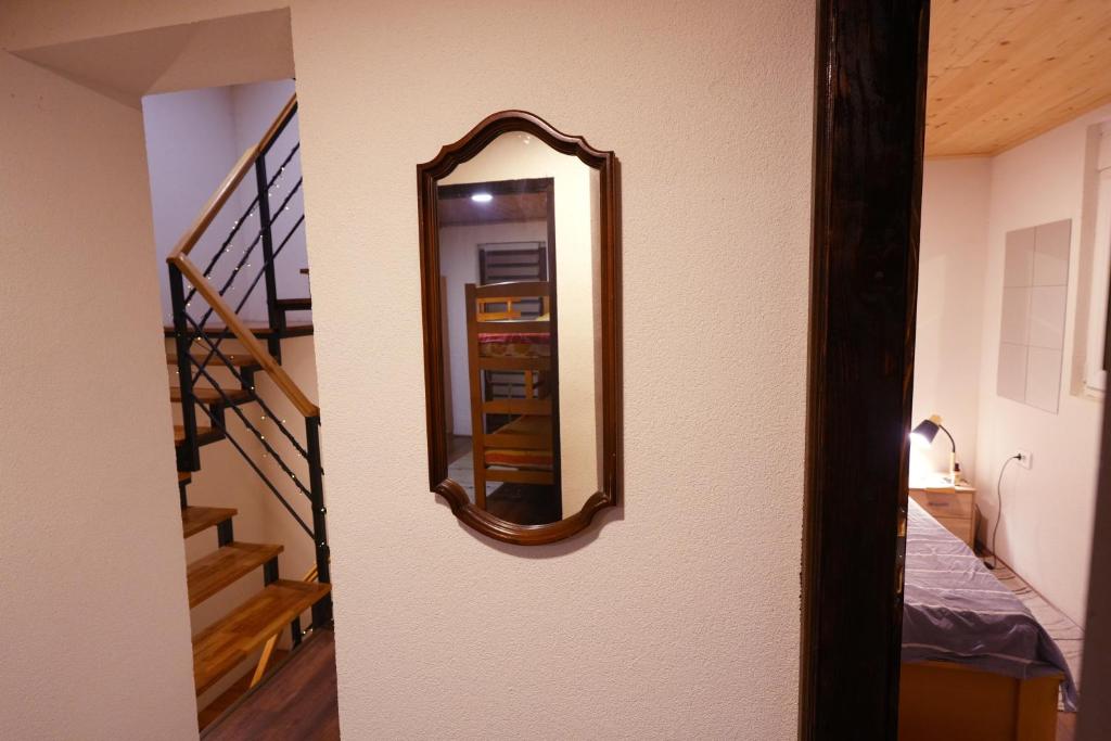 a mirror on a wall next to a staircase at Mladenović Kuća in Kopaonik