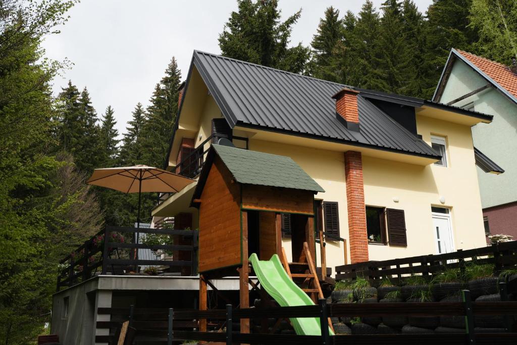 a house with a play structure in front of it at Mladenović Kuća in Kopaonik