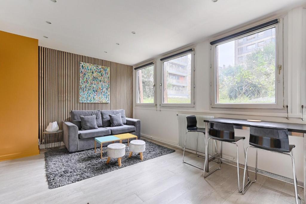 un salon avec un canapé et une table dans l'établissement Beaugrenelle Tour Eiffel I Cosy Apartment 4P, à Paris