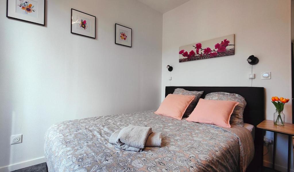 une chambre avec un lit avec des oreillers roses dans l'établissement Charmant T2 Rénové, Calme & Lumineux, Paris 17e, à Paris