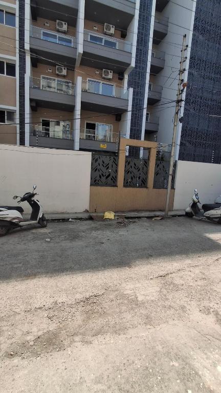 deux scooters sont garés devant un bâtiment dans l'établissement Mrityunjay Yogpeeth, à Jāmb