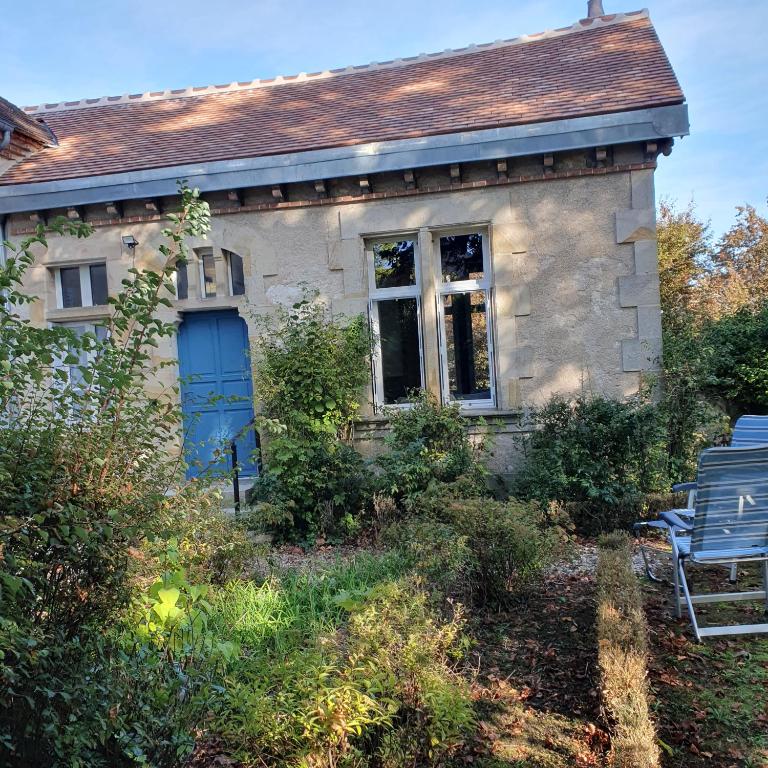 une ancienne maison en pierre avec une porte bleue dans l'établissement Maison la Paroisse, proche des Thermes, à Bourbon-lʼArchambault
