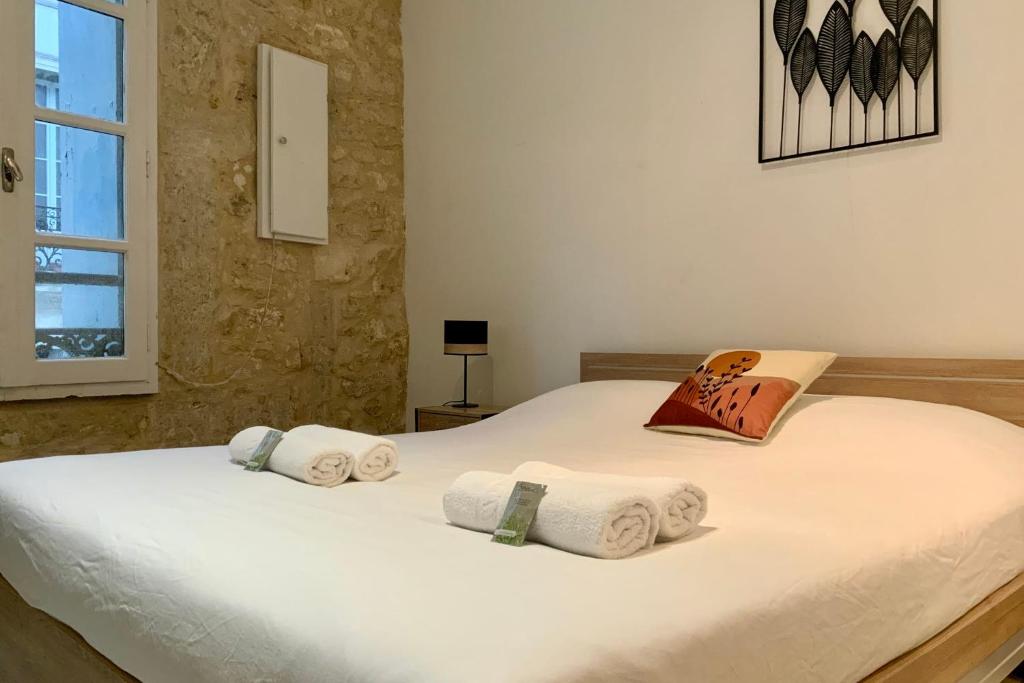 une chambre avec un lit blanc avec des serviettes dessus dans l'établissement Le Coquet - Studio with air conditioning!, à Montpellier