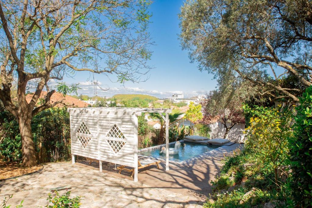 une piscine extérieure avec un banc et des arbres dans l'établissement La canopée familiale, à Montpellier
