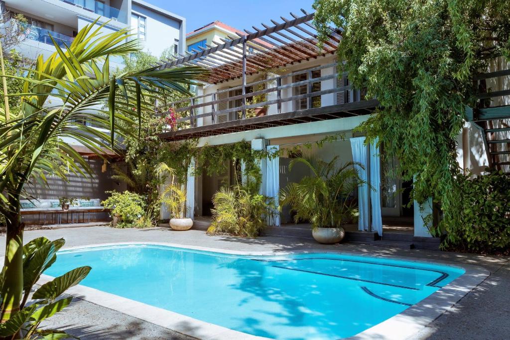 ケープタウンにあるCape Standard Guest Houseの建物の前にスイミングプールがあるアパートメント