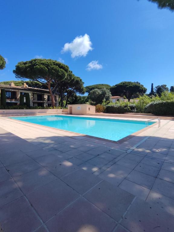 une piscine vide avec des arbres en arrière-plan dans l'établissement Appartement Les Issambres 4 pers, à Roquebrune-sur Argens