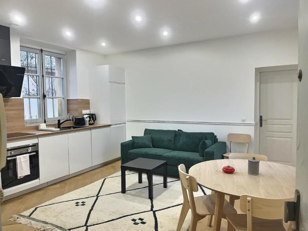 un salon avec un canapé vert et une table dans l'établissement Château Versailles, logement Neuf, à Versailles