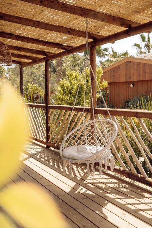 a swinging chair on a porch with a wooden deck at Toison D'or in Saint-Tropez