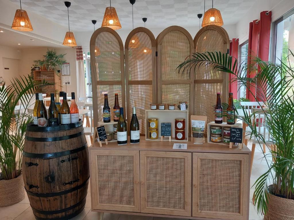 a bar with bottles of wine and a barrel at Motel Les Broussailles in Mesves-sur-Loire