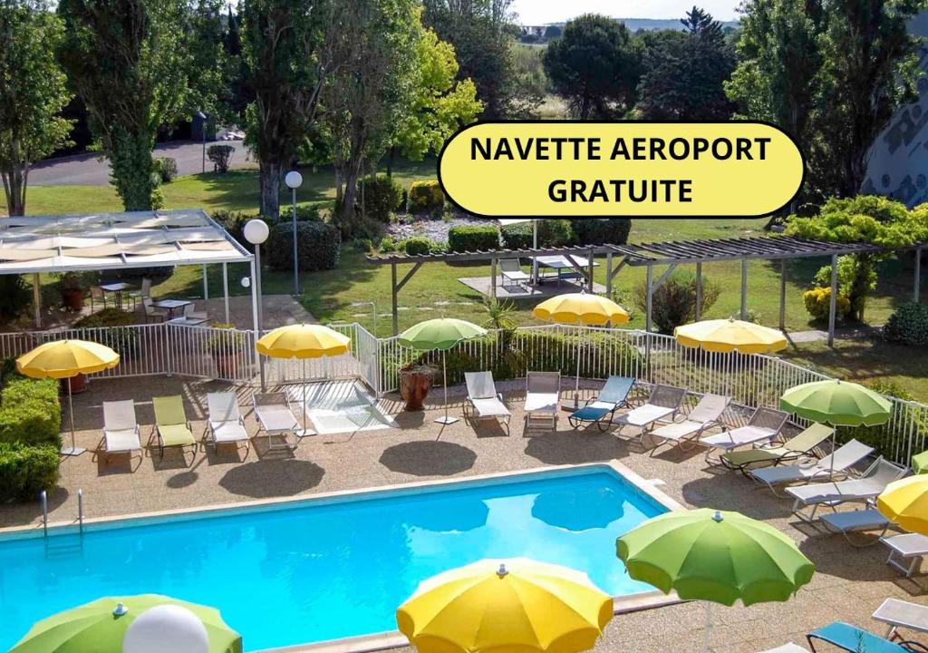 une piscine avec parasols et chaises et un groupe dans l'établissement ibis Styles Marseille Aéroport, à Vitrolles