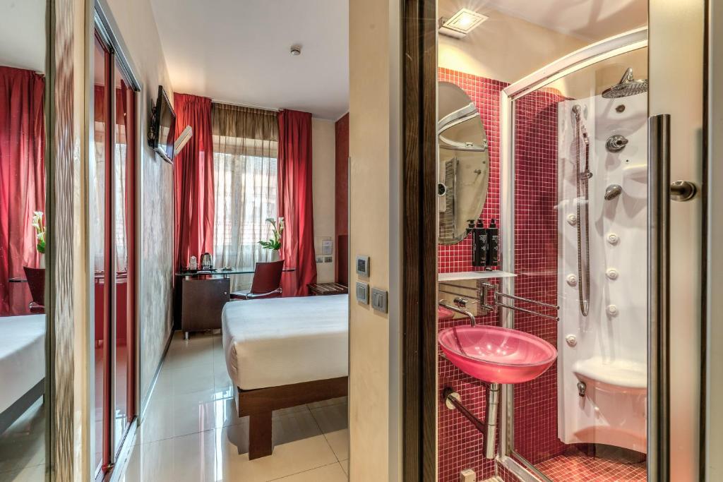 Un baño con lavabo rosa y un dormitorio. en La Griffe Hotel Roma, en Roma