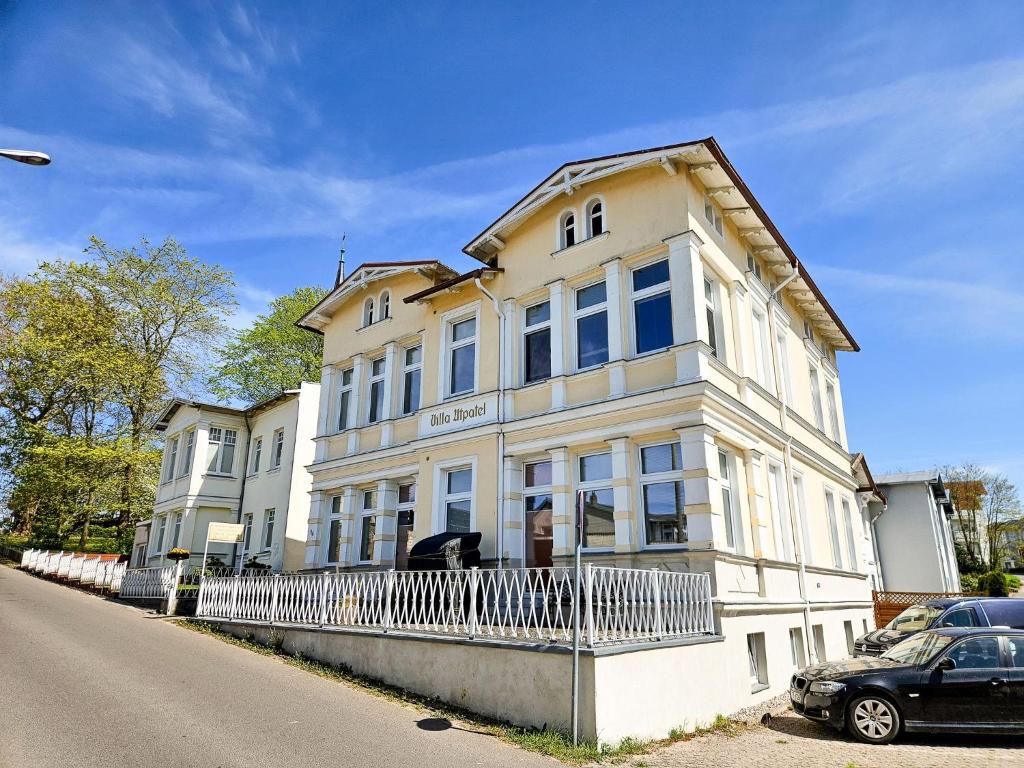 a white building with a car parked in front of it at Villa Utpatel Whg 03 in Ahlbeck