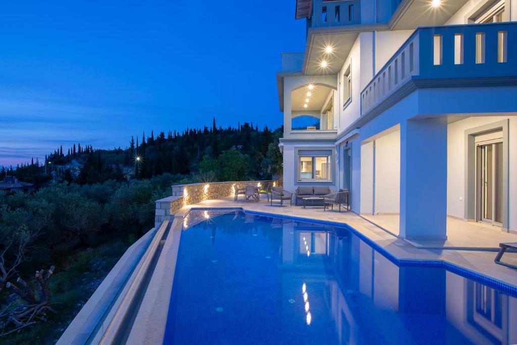 a house with a swimming pool at night at Emilia Villas in Agios Nikitas