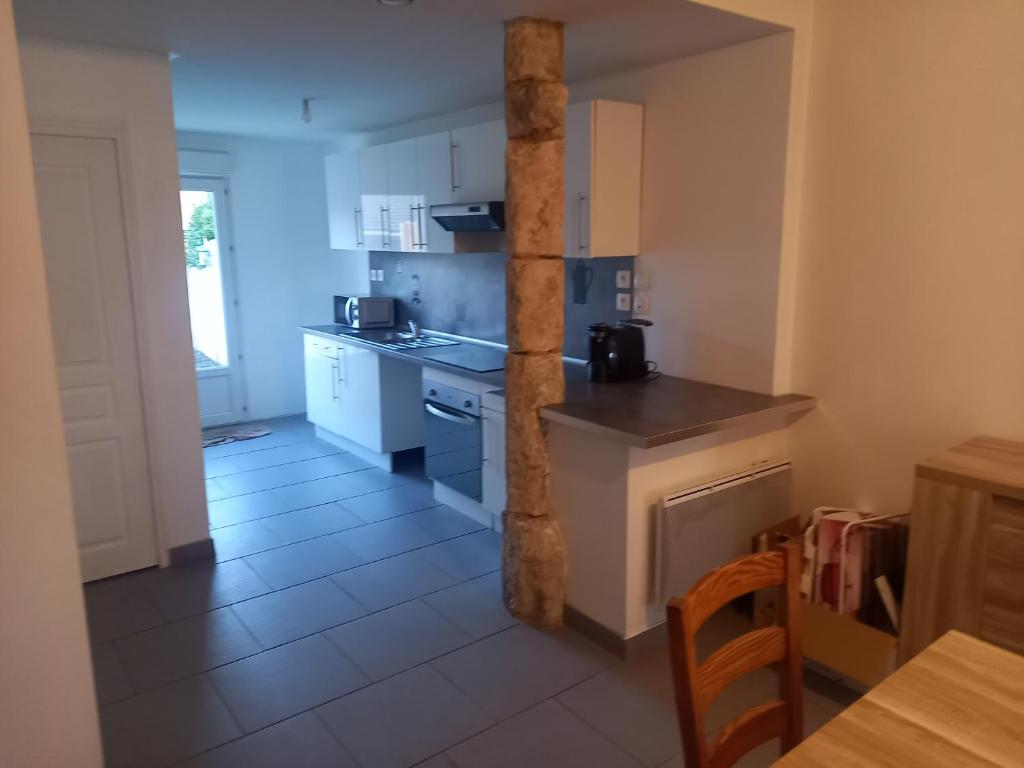 une cuisine équipée d'appareils électroménagers blancs, d'une table et d'un sidx de table dans l'établissement le cantalou, à Rinxent