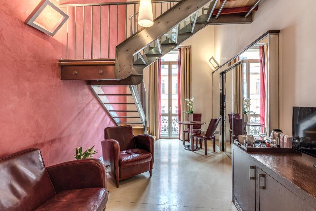 una sala de estar con una escalera en un edificio en La Griffe Hotel Roma, en Roma