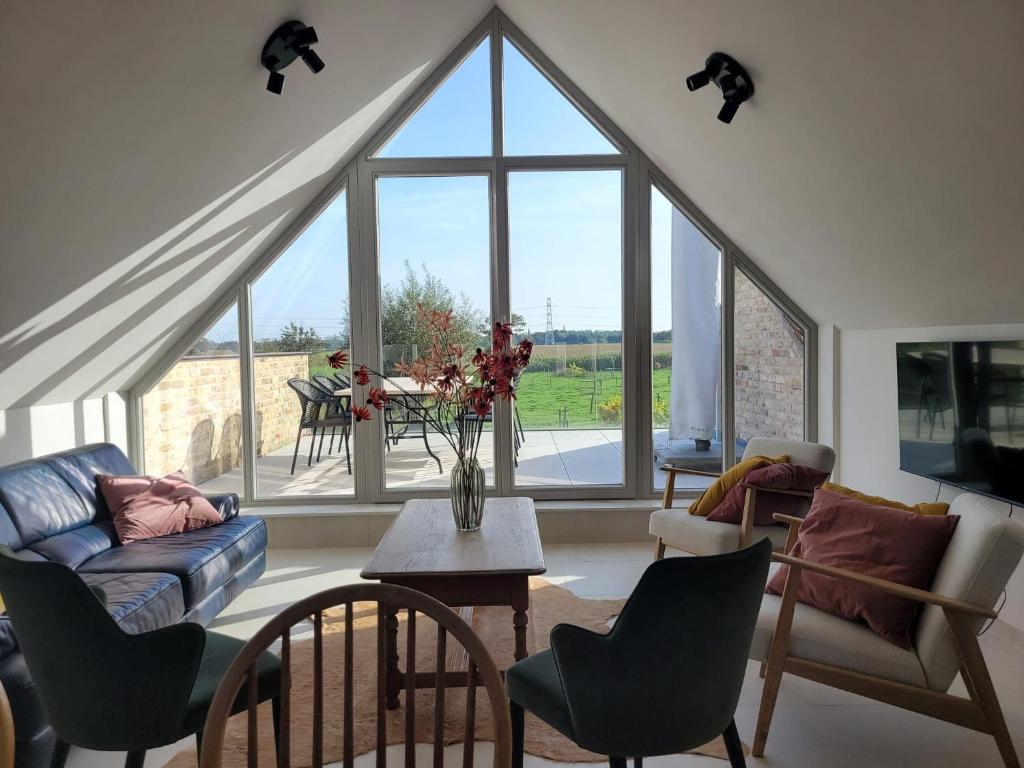 a living room with a large window and a couch at Het Weiland Villa Jersey in Damme