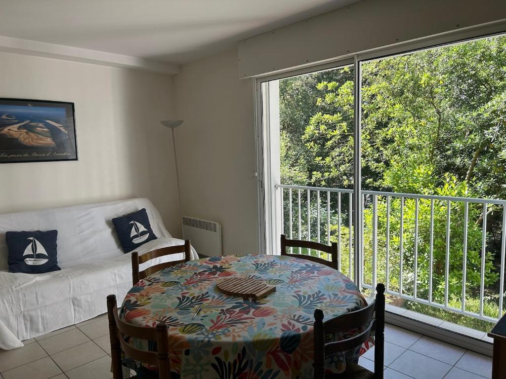 - un salon avec une table, un canapé et une fenêtre dans l'établissement Appartement pereire plage a pied, à Arcachon