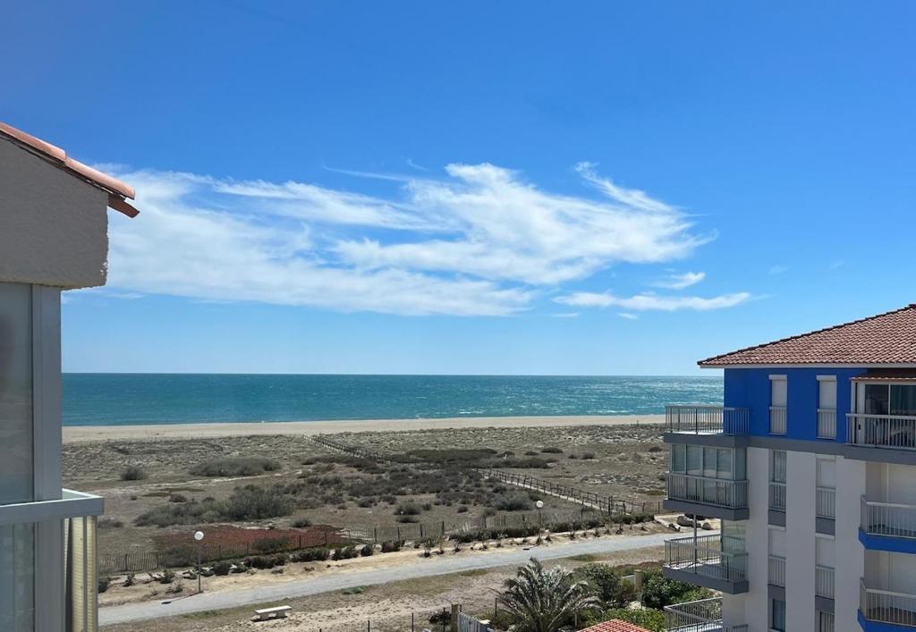 a view of the beach from the balcony of a building at évasion méditerranéenne - vue mer - plage in Le Barcarès
