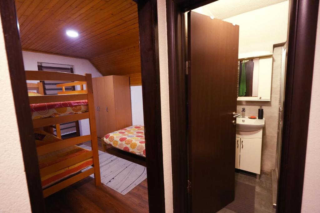 a small room with a bunk bed and a bathroom at Mladenović Kuća in Kopaonik