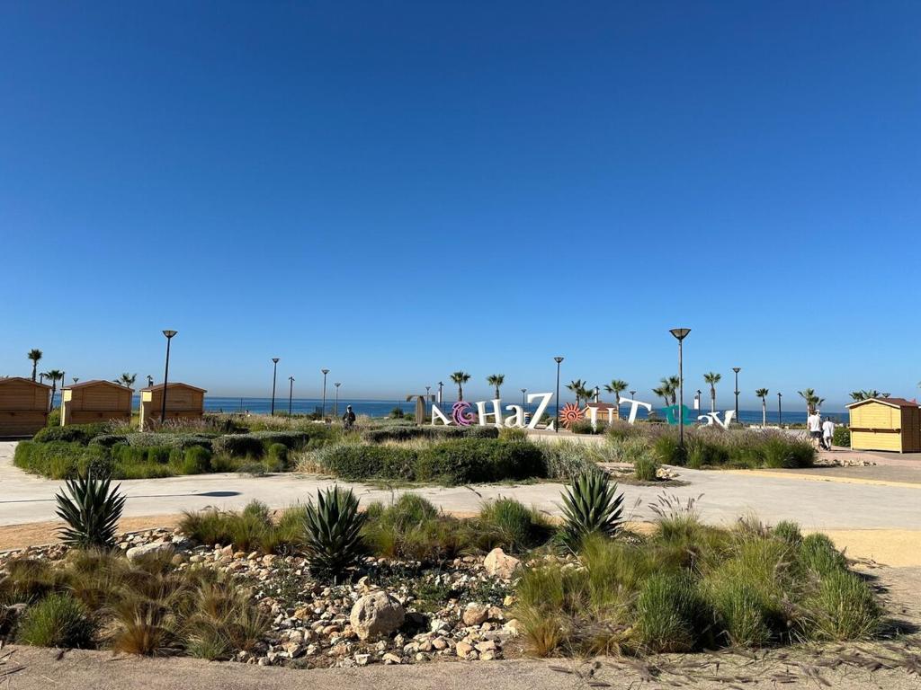 a parking lot at the beach with palm trees at Blue Hope Duplex with sea and mountain views in Taghazout